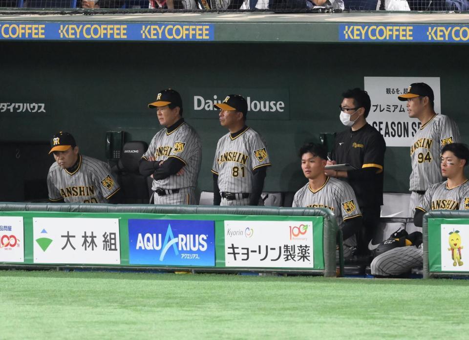 　９回、巨人に敗れてベンチで厳しい表情を見せる岡田監督（左端）と佐藤輝（右端）＝撮影・堀内翔