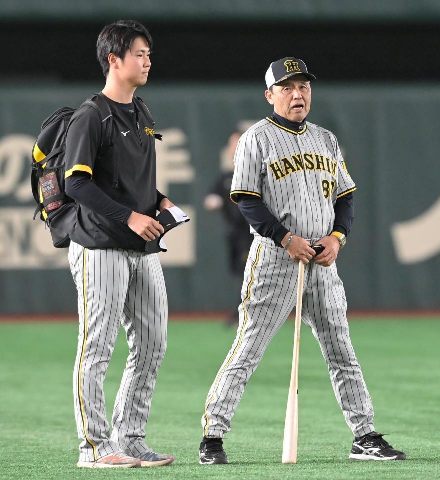 　試合前、練習を終えた浜地（左）に声をかける岡田監督（撮影・高部洋祐）