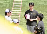 　試合前、安藤投手コーチ（左）らと会話する湯浅（中央）＝撮影・伊藤笙子