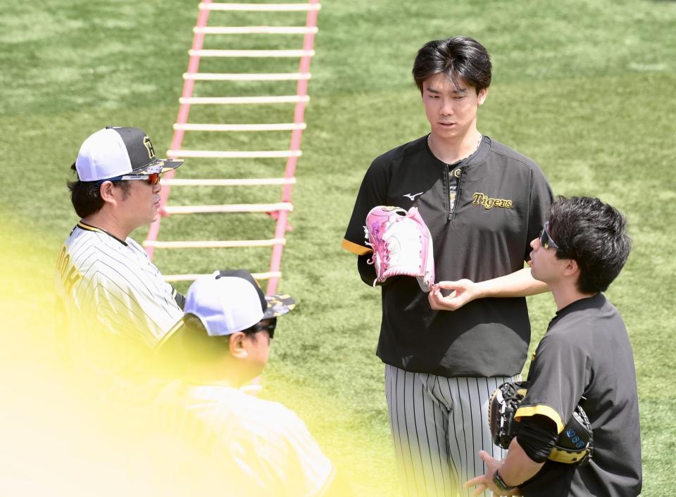 　試合前、安藤投手コーチ（左）らと会話する湯浅（中央）＝撮影・伊藤笙子