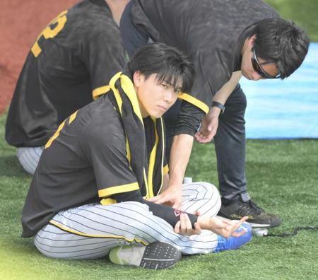 　トレーナーとともに右腕の状態を確認する湯浅＝１６日