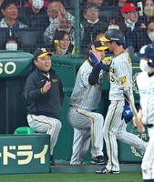 ７回、中野の適時打で生還した近本（右）を迎えて笑顔を見せる岡田監督（撮影・立川洋一郎）