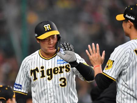 １回、梅野の遊ゴロで勝ち越しの生還を果たした三走の大山（左）。西純とタッチを交わす（撮影・中田匡峻）