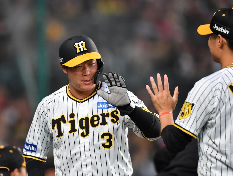 １回、梅野の遊ゴロで勝ち越しの生還を果たした三走の大山（左）。西純とタッチを交わす（撮影・中田匡峻）