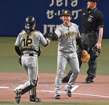 　笑顔で坂本にマスクを手渡す村上（撮影・飯室逸平）