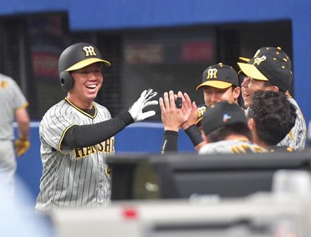 　６回、近本の適時三塁打で生還し、ナインの出迎えに笑顔で応える村上（撮影・立川洋一郎）