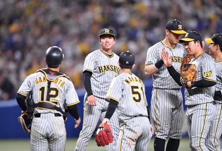 　ナインがタッチを交わす中、プロ初勝利を挙げた村上（左から２人目）は坂本（１２）から声をかけられ、少し頬が緩む（撮影・中田匡峻）