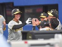 　６回、近本の適時三塁打で生還し、ナインの出迎えに笑顔で応える村上（撮影・立川洋一郎）