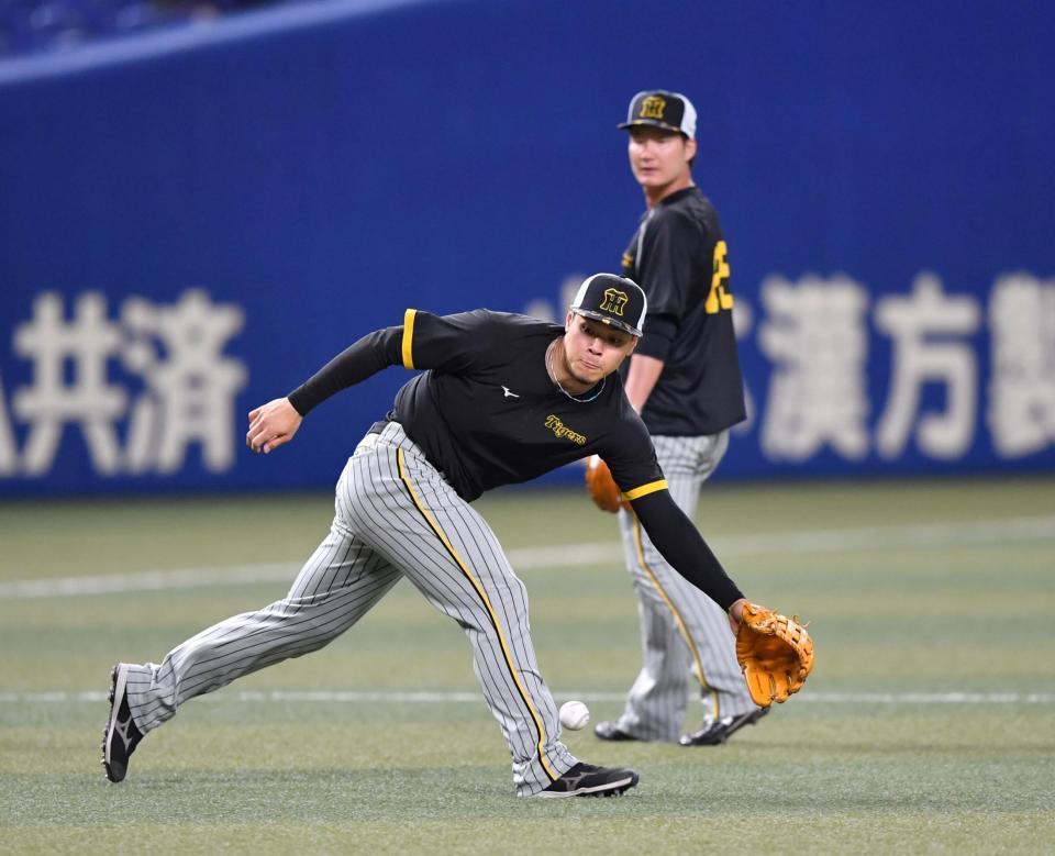 　ノックを受ける佐藤輝。後方は渡辺諒（撮影・中田匡峻）