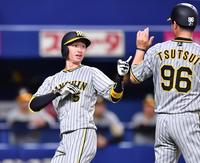 　１回、ライトスタンドへ先制の先頭打者本塁打を放ち、生還する近本（左）＝撮影・中田匡峻