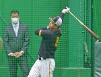 　福留孝介氏（左）の前でフリー打撃をする佐藤輝（撮影・立川洋一郎）