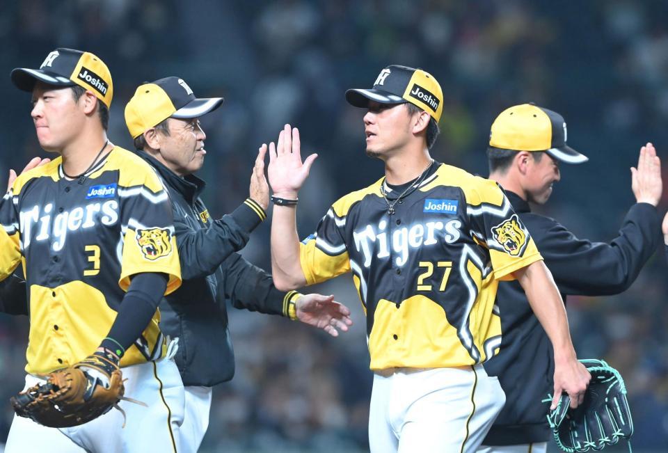 　完封星を挙げ、岡田監督（左から２人目）とタッチを交わす伊藤将（撮影・高部洋祐）