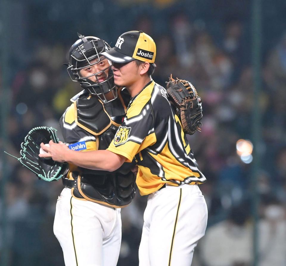 　完封星を挙げ、坂本（左）と抱き合う伊藤将（撮影・高部洋祐）