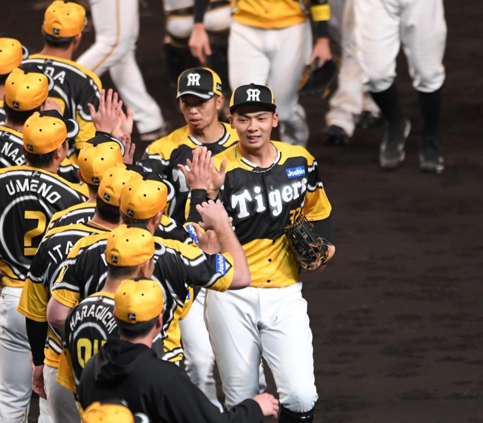 　勝利を飾り、ナインとタッチを交わす井上（中央）＝撮影・北村雅宏