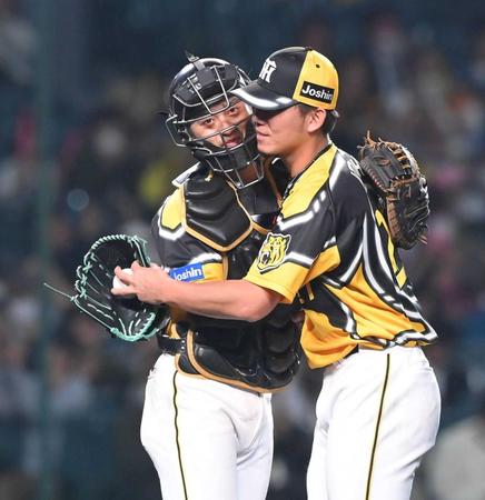 　完封勝利の伊藤将（右）と抱き合う坂本（撮影・高部洋祐）
