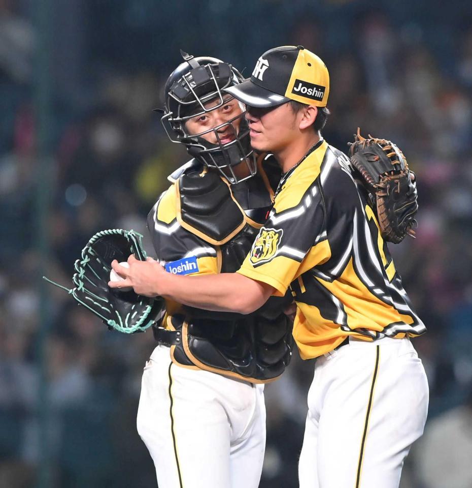 　完封勝利の伊藤将（右）と抱き合う坂本（撮影・高部洋祐）