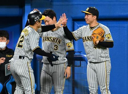 ５回、近本の右前適時打で生還の坂本を迎える村上（撮影・金田祐二）