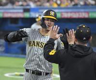 　５回、先制ソロを放ち、ナインとタッチを交わす佐藤輝（撮影・高部洋祐）