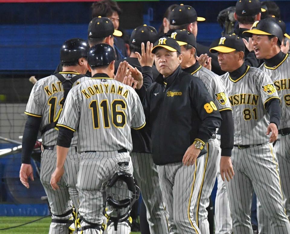 　ヤクルトに連勝し、ナインとタッチを交わす岡田監督（中央）