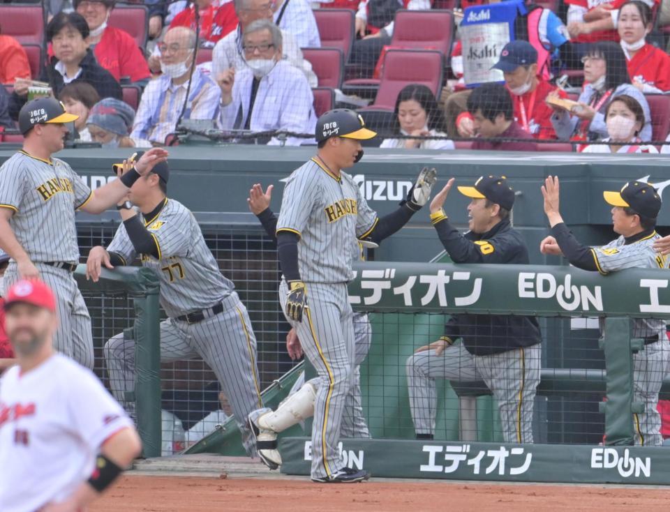 １回、先制２ランを放って生還し岡田監督（右から２人目）とタッチを交わす大山（撮影・立川洋一郎）