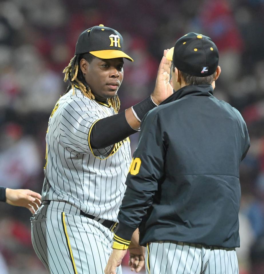 　広島に快勝し、岡田監督（右）とタッチを交わすミエセス（撮影・高部洋祐）