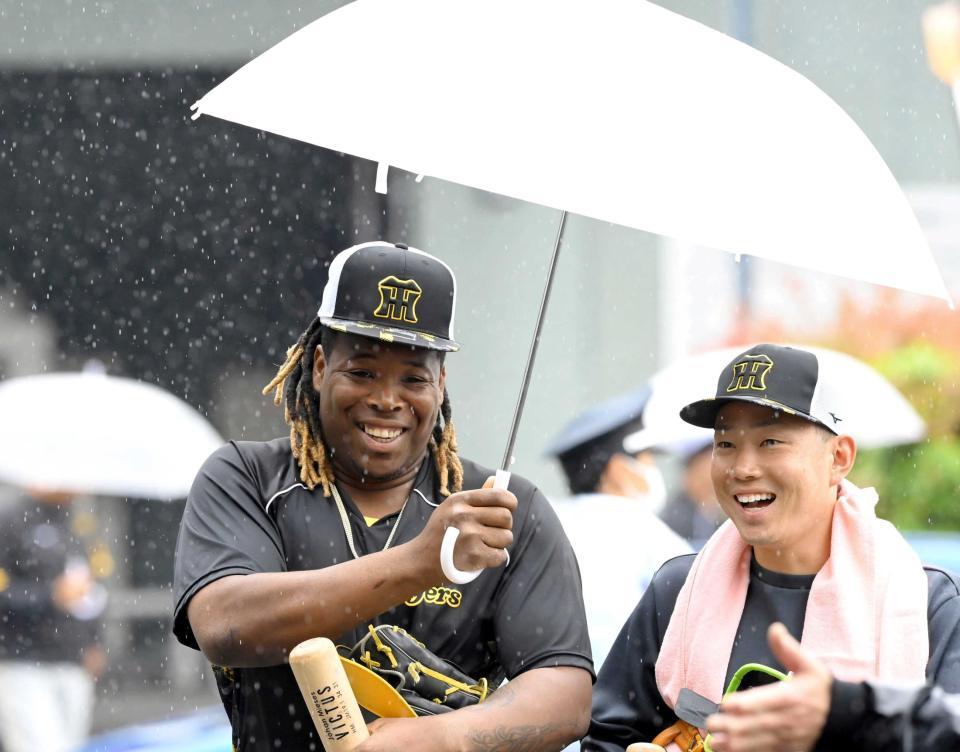 　糸原（右）と相合い傘で室内練習場へ向かうミエセス（撮影・高部洋祐）