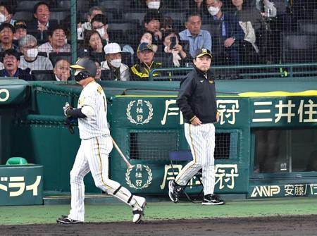 　８回の攻撃を終え、選手交代に向かう岡田監督（右）と空振り三振に倒れた大山＝９日