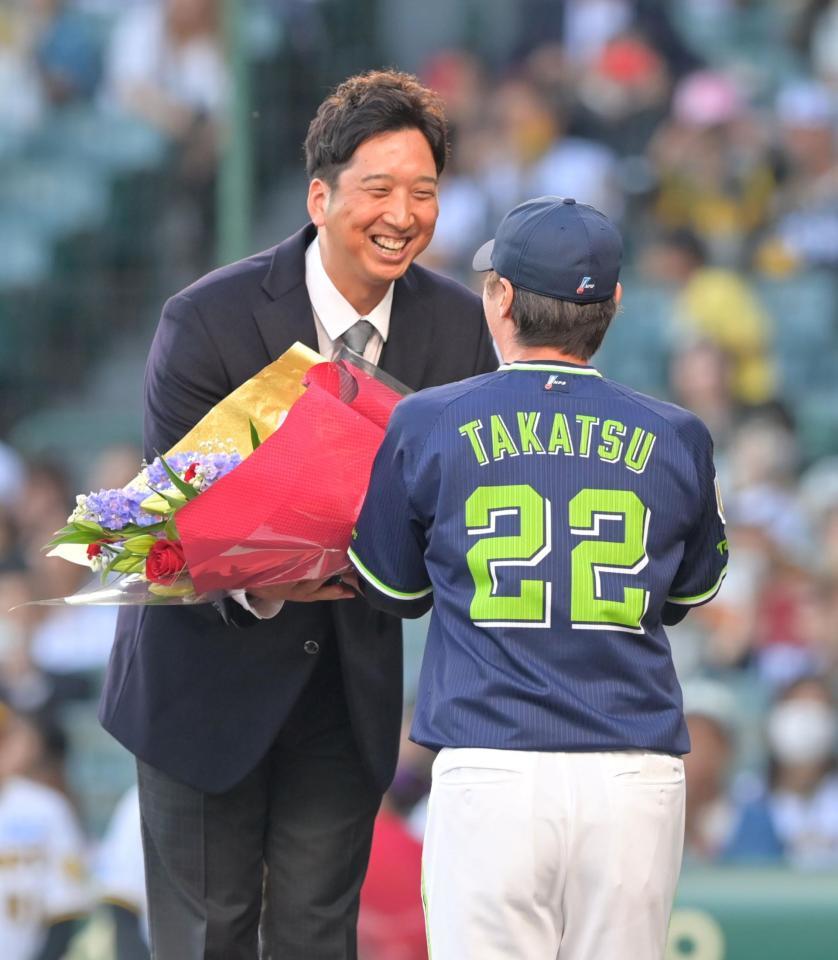 　高津監督から花束を手渡され笑顔を見せる藤川ＳＡ（撮影・立川洋一郎）