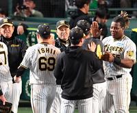 　ヤクルトに勝利し、ナインとタッチを交わす岡田監督（中央）＝撮影・中田匡峻
