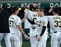 　プロ初勝利の石井（右）は伊藤将とタッチを交わす（撮影・中田匡峻）