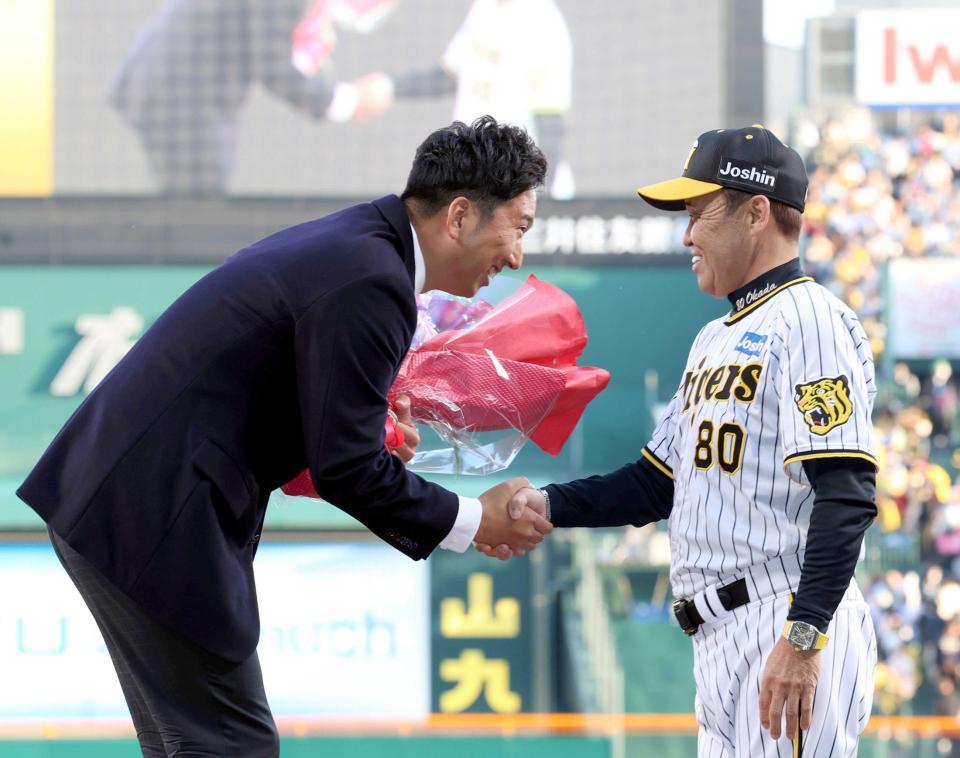 　名球会ブレザーを贈られた藤川ＳＡ（左）と握手を交わす岡田監督（撮影・山口登）