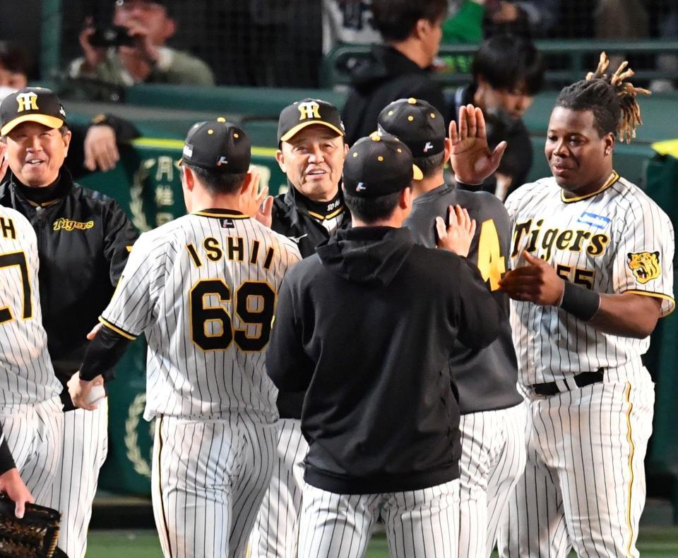 　ヤクルトに勝利し、ナインとタッチを交わす岡田監督（中央）＝撮影・中田匡峻