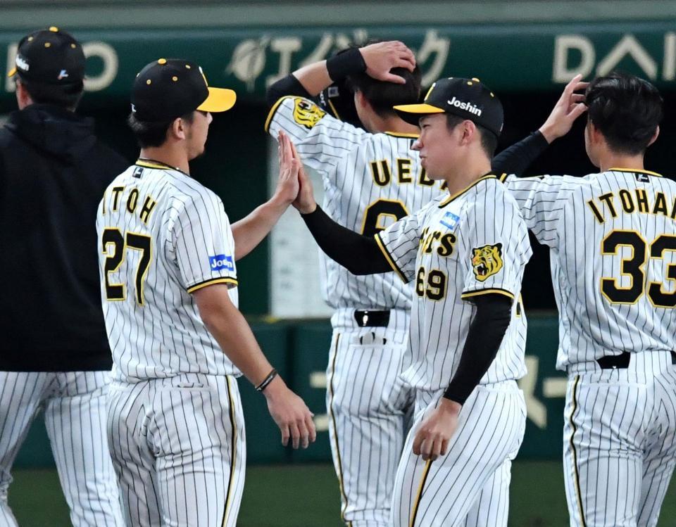 　プロ初勝利の石井（右）は伊藤将とタッチを交わす（撮影・中田匡峻）