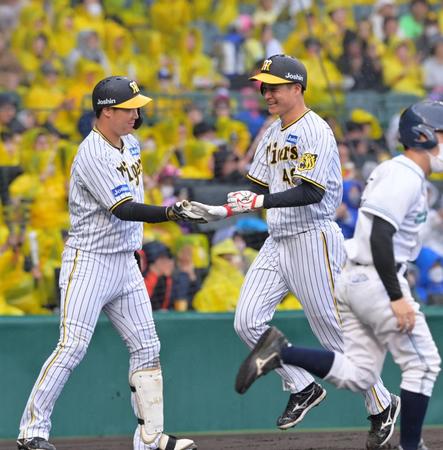 　３回、ノイジーの中犠飛で勝ち越しの生還を果たし、大山（左）と笑顔でタッチを交わす大竹（撮影・立川洋一郎）