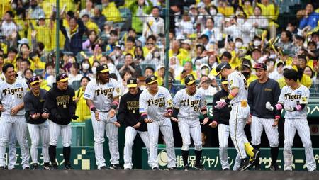 　４回、右中間に満塁本塁打を放った佐藤輝（８）を迎える阪神ナイン（撮影・中田匡峻）