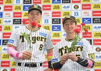 　カーネーションを手に笑顔を見せる佐藤輝（左）と近本（撮影・高部洋祐）