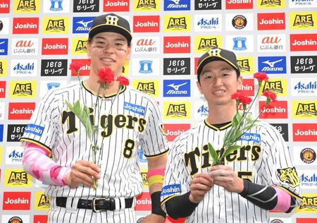 　カーネーションを手に笑顔を見せる佐藤輝（左）と近本（撮影・高部洋祐）