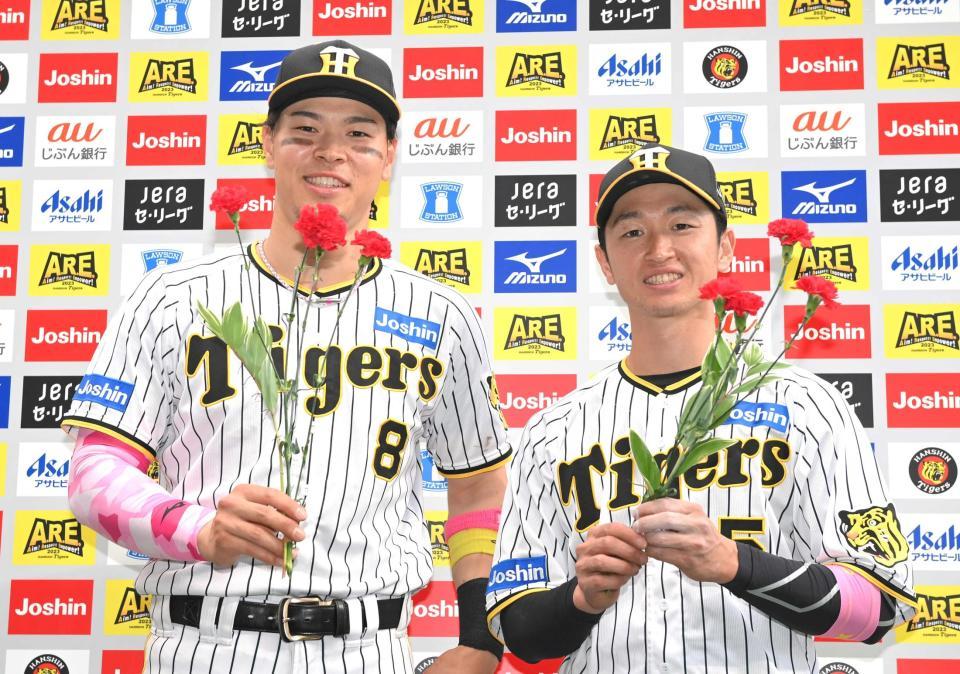 　カーネーションを手に笑顔を見せる佐藤輝（左）と近本（撮影・高部洋祐）