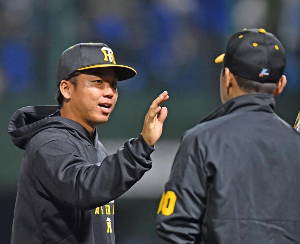 　中日に勝利し、岡田監督（右）とタッチを交わす村上（撮影・中田匡峻）