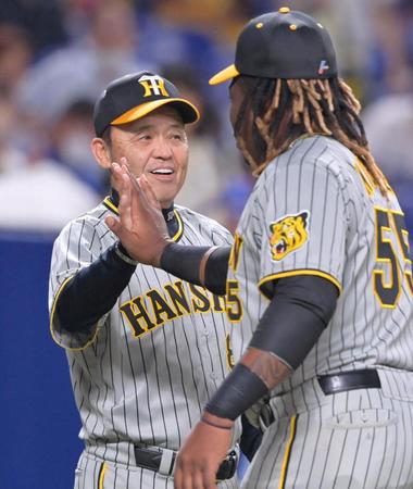 　７連勝で貯金を１０に伸ばし、ミエセス（右）とタッチを交わして笑顔を見せる岡田監督（撮影・立川洋一郎）