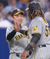 　７連勝で貯金を１０に伸ばし、ミエセス（右）とタッチを交わして笑顔を見せる岡田監督（撮影・立川洋一郎）