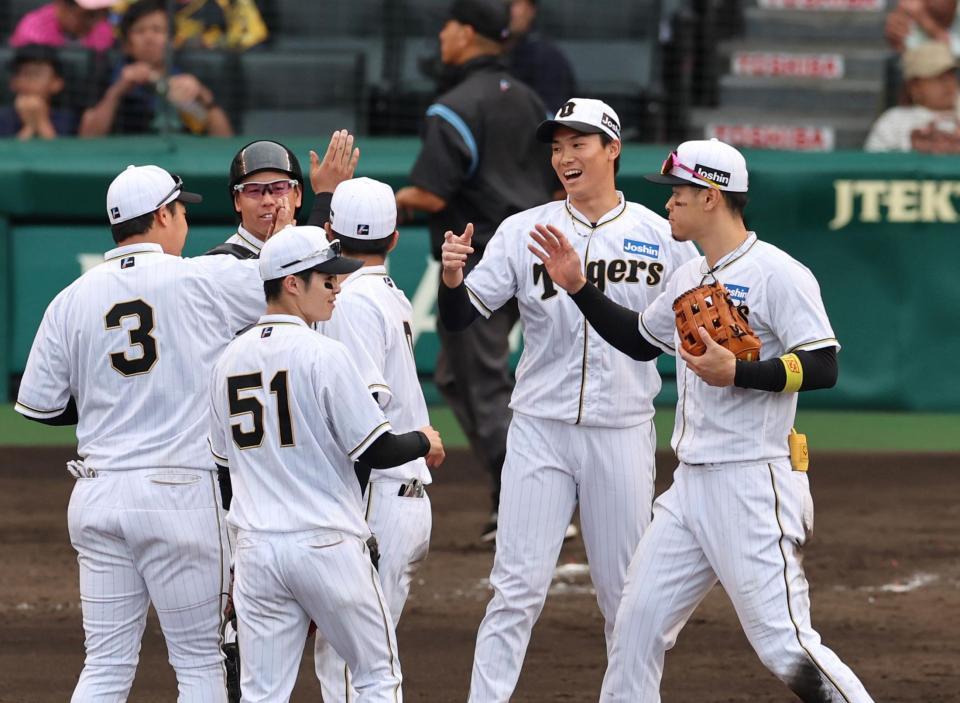 　セーブを挙げた湯浅（中央右）はナインとタッチする（撮影・山口登）