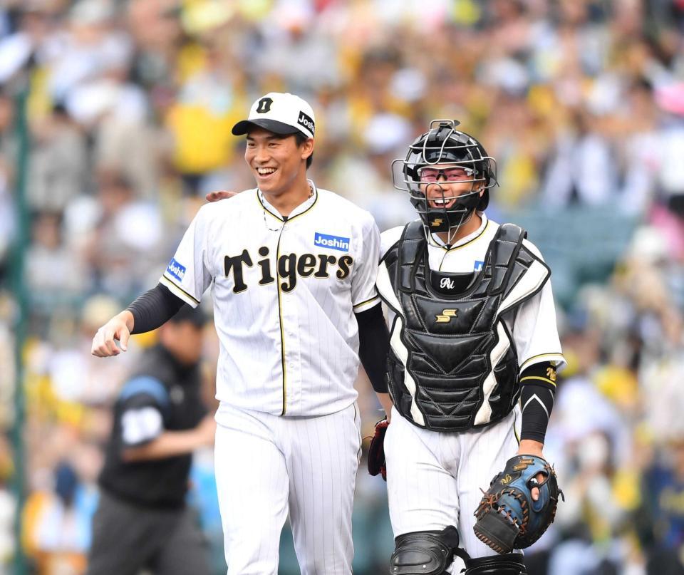 　最後を締めて復帰後初セーブの湯浅（左）とねぎらう梅野（撮影・中田匡峻）