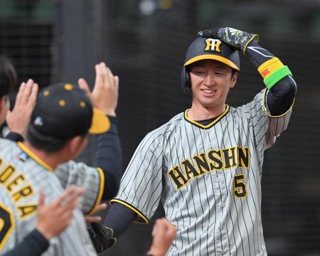 　１回、中野の適時三塁打で先制のホームを踏み、ナインの出迎えに笑顔を見せる近本（撮影・立川洋一郎）