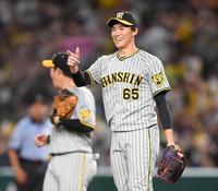 　９回を三者凡退に抑え笑顔を見せる湯浅（撮影・棚橋慶太）