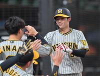 　１回、ノイジーの遊ゴロで生還し、ナインの出迎えに笑顔を見せる中野（撮影・立川洋一郎）