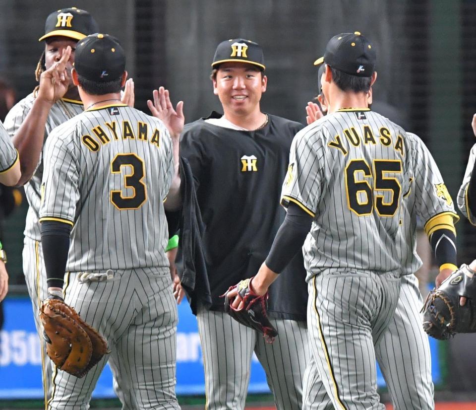 　５勝目を挙げ、笑顔でナインとタッチを交わす村上（中央）＝撮影・西岡正