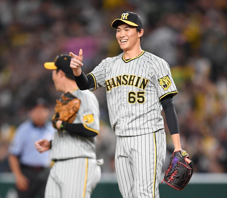 　９回を三者凡退に抑え笑顔を見せる湯浅（撮影・棚橋慶太）