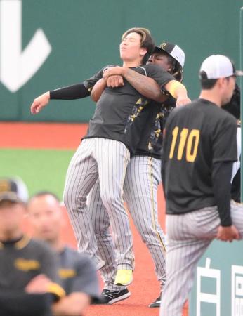 　梅野を抱えてストレッチをするミエセス（撮影・堀内翔）