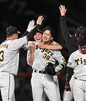 　サヨナラで試合を決め、ナインから祝福される小幡（撮影・飯室逸平）